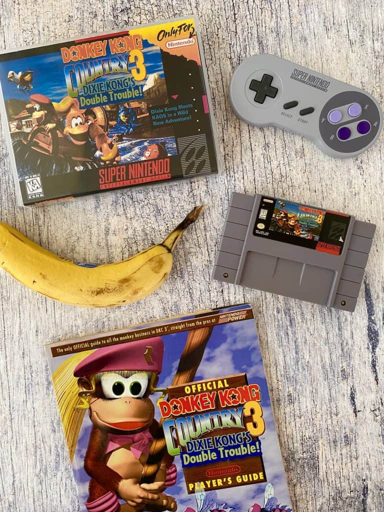 Donkey Kong Country 3 box, cart, player's guide, SNES controller, and banana