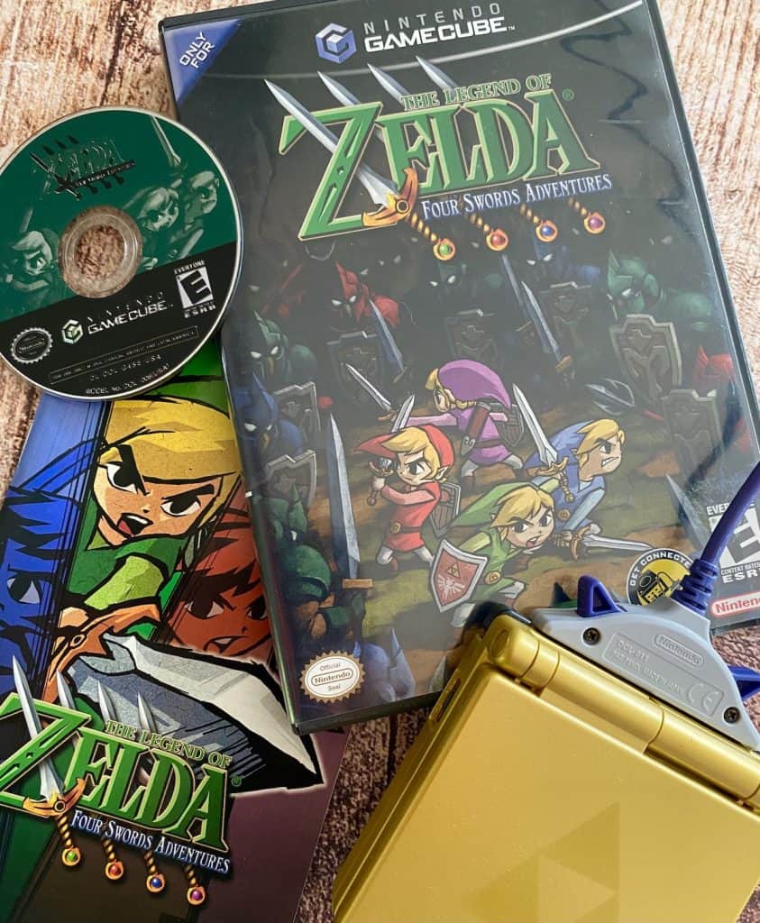 Zelda Four Swords Adventures case, disc, manual, and Zelda GBA SP with GC link cable