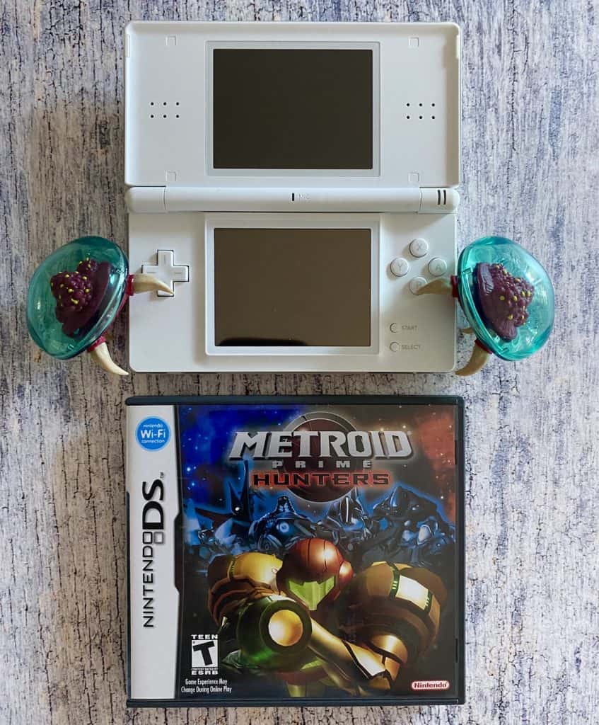 Metroid Prime Hunters with DS Lite and two Metroid figures